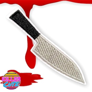 May include: White embroidered knife patch with a black handle. The patch is surrounded by a red stain.