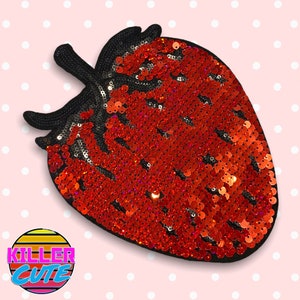 May include: Red sequin strawberry patch with black felt backing.