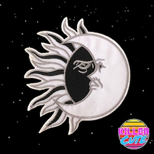 May include: Embroidered patch featuring a celestial design of a sun and moon. The sun is on the left, with white and black rays, and the moon is on the right, with a black and white face. The background is black with white stars.