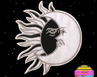 May include: Embroidered patch with a celestial design of a sun and moon. The sun has white and black rays, and the moon has a black and white face. The background is black with white stars. The patch has the text "KILLER CUTE".