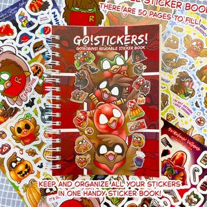 Op de afbeelding: Een herbruikbaar stickerboek met de titel "Go! Stickers!" met een rode kaft en cartoon illustraties van roodborstjes. Verschillende sticker vellen met roodborstjes en andere ontwerpen omringen het boek. De tekst "Go! Robins!" is zichtbaar.