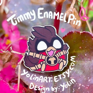 Può includere: Uno spillo in smalto rosso e marrone con un uccello dei cartoni animati con un becco rosso e occhi bianchi. Lo spillo è circondato da fiori rosa e foglie verdi. Il testo "Timmy Enamel Pin" è scritto in bianco su uno sfondo bianco sopra lo spillo. Il testo "YolinART. ETSY.com Design by: Yolin" è scritto in bianco su uno sfondo marrone sotto lo spillo.