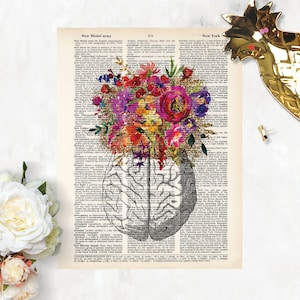 Op de afbeelding: Een vintage boekpagina met een aquarelillustratie van een boeket kleurrijke bloemen dat groeit uit een menselijk brein. De tekst op de pagina is uit een woordenboekvermelding voor "New Model Army" en "New York".
