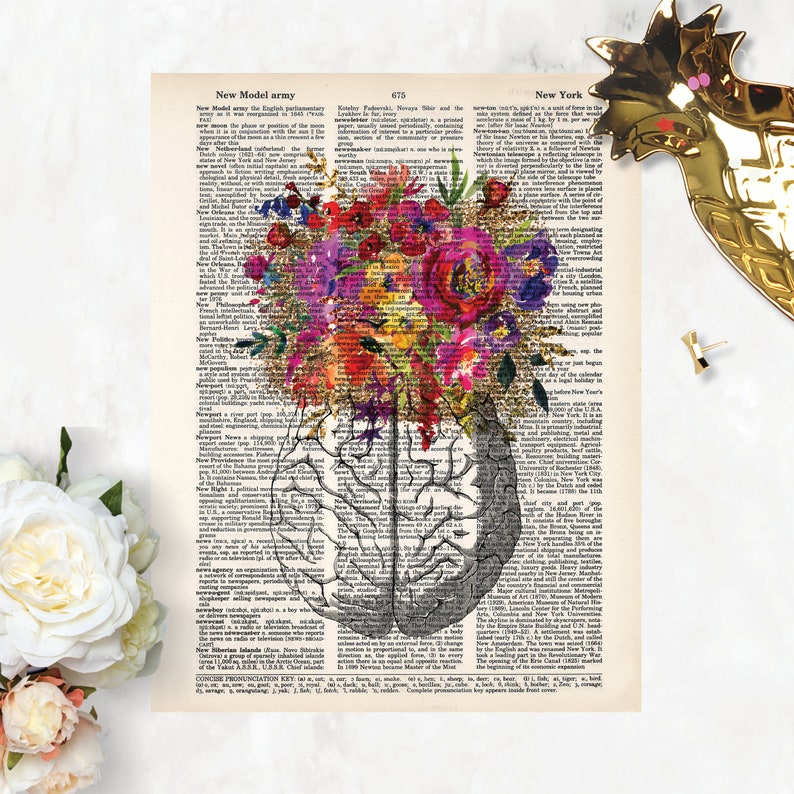 Op de afbeelding: Een vintage boekpagina met een aquarelillustratie van een boeket kleurrijke bloemen dat groeit uit een menselijk brein. De tekst op de pagina is uit een woordenboekvermelding voor "New Model Army" en "New York".