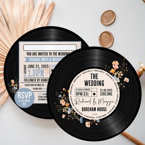 May include: Black and white vinyl record wedding invitation with floral accents. The text reads "The Wedding" with the couple's names and wedding date.  The invitation is decorated with a floral design in shades of orange, yellow, and blue.