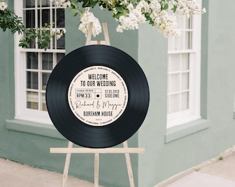 May include: Black vinyl record with a white label that says "Welcome to our wedding" with the date "12.01.2019", names "Richard & Maggie", and the location "Boreham House".