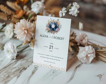 May include: A wedding invitation with a floral design featuring a vintage record player. The invitation is for Alexa and Robert, and the wedding is scheduled for June 21, 2025, at The Caves, 8-10 Niddry St South Edinburgh.