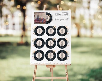May include: A white wedding seating chart with a vintage record theme. The chart features a photo of the couple and the names "India and Luke" with the date "Saturday 25th November 2023". The chart has the words "Find your seat" and is decorated with floral illustrations.