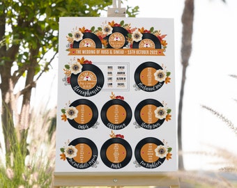 May include: A wedding seating chart with a fall theme. The chart features a black and white record design with the names of the tables written in white. The top table is labeled "The Top Table" with the names Ross & Sinead and the date 15.10.22. The table names are: Stereophonics, Oasis, Offspring, Fleetwood Mac, Steely Dan, Red Hot Chilli Peppers, Pink, and Foo Fighters.