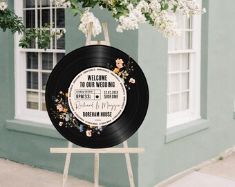 May include: Black vinyl record with a white label and floral design. The label says "Welcome to our wedding", "Stereo 10012018", "RPM 33", "12.01.2019", "Side One", "Richard & Maggie", and "Boreham House".