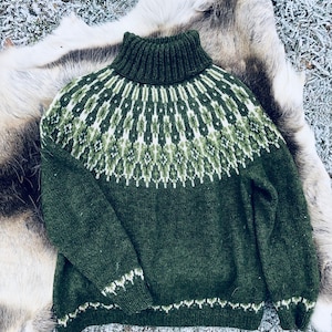 May include: A green knit sweater with a high collar and a patterned yoke in shades of green and white. The sweater is displayed on a fur-like surface, showcasing its textured design and cozy aesthetic. The sweater's cuffs and hem feature a white trim.