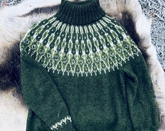 Puede incluir: Un suéter verde tejido con cuello alto y canesú estampado en tonos verdes y blancos. El suéter se exhibe sobre una superficie similar a la piel, mostrando su diseño texturizado. Los puños y el dobladillo tienen un ribete blanco.