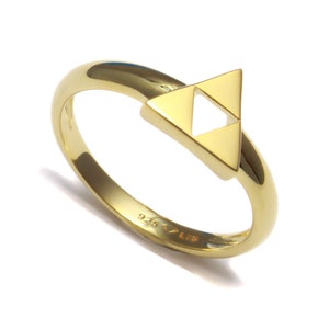Könnte beinhalten: Ein goldfarbener Ring mit einem dreieckigen Design, das ein kleineres Dreieck im Inneren aufweist. Der Ring ist mit "925" und "LTD" gekennzeichnet.