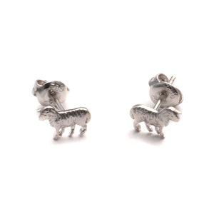 Puede incluir: Un par de pendientes de plata con un diseño detallado de una oveja. Los pendientes son pequeños y delicados, perfectos para el uso diario.