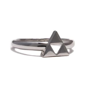 Könnte beinhalten: Ein silberner Ring mit einem dreieckigen Design. Das Dreieck hat ein kleineres Dreieck, das aus seiner Mitte herausgeschnitten ist.
