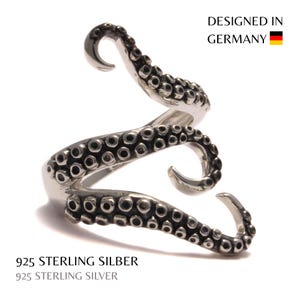 Könnte beinhalten: Ein silberner Ring in Form eines Oktopus-Tentakels mit detaillierten Saugnäpfen. Der Ring windet sich spiralförmig um den Finger. Der Text "DESIGNED IN GERMANY" ist sichtbar. Der Ring ist aus 925er Sterlingsilber gefertigt.