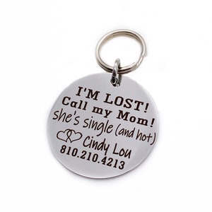 K&ouml;nnte beinhalten: Silberner Schl&uuml;sselanh&auml;nger mit einem runden Anh&auml;nger, auf dem steht "I'M LOST! Call my Mom! She's single (and hot) Cindy Lou 810.210.4213".