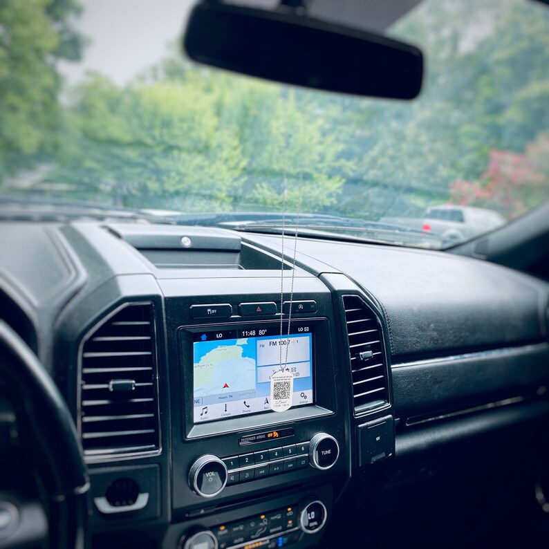 Picture of a memorial qr code keychain on a 30 inch ball chain hanging from a rearview mirror.