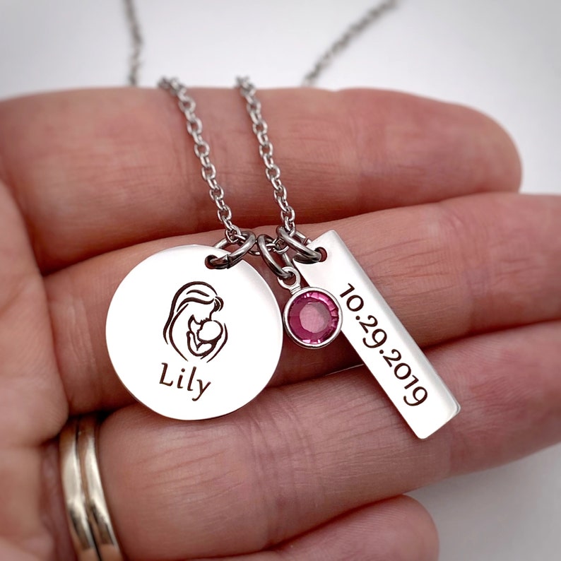 silver mom necklace on a womans hand to show size