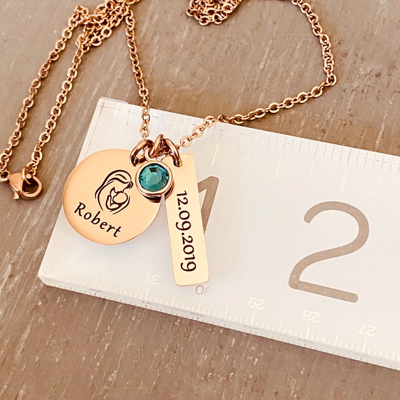 rose gold mom necklace on a ruler to show the main pendant the size.875 inches