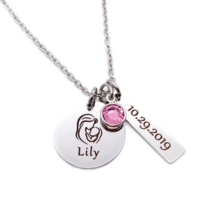 Mom Silver Charm Necklace with a 1 inch round pendant engraved with a mom and baby image and the daughter's name Lily. next charm is a pink October birthstone. next charm is a rectangle tag engraved with the date 10.29.19.