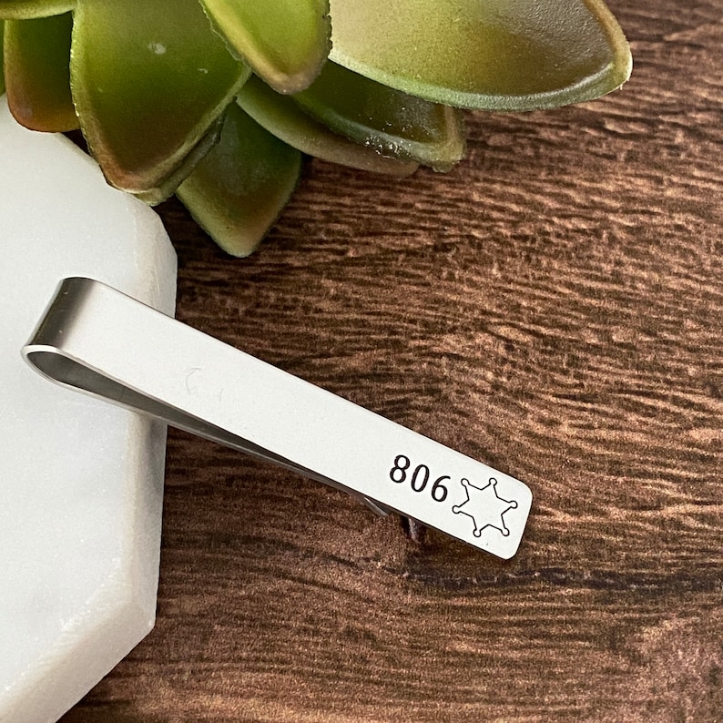 silver stainless steel tie bar clip engraved with deputy badge number 806 and the sheriff 6 point star