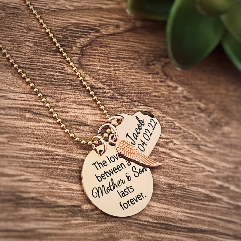 Puede incluir: Collar de oro con dos colgantes. El colgante m&aacute;s grande es redondo y dice "El amor entre una madre y su hijo dura para siempre". El colgante m&aacute;s peque&ntilde;o tiene forma de coraz&oacute;n y dice "Jacob 04.02.22".