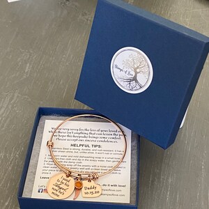May include: A gold-toned bracelet with charms that say "I used to be his Angel now he's mine" and "Daddy 10.15.20". The bracelet is in a blue box with a white logo that says "Stamp's A Love".