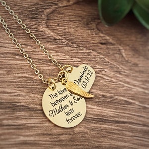 Puede incluir: Collar de oro con dos colgantes. El colgante m&aacute;s grande es redondo y dice "El amor entre una madre y su hijo dura para siempre". El colgante m&aacute;s peque&ntilde;o tiene forma de coraz&oacute;n y dice "Dominic 03.17.22".