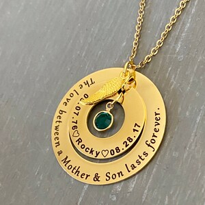 Yellow Gold Memorial necklace for mom who lost a son. outer ring engraved with sweet phrase inside ring engraved with sons information. The 2 large pendants are connected to a cable chain and dangle a angel wing charm and sons birthstone.