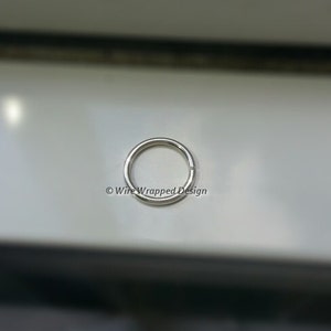 May include: A silver jump ring, a small metal ring used for connecting jewelry components.