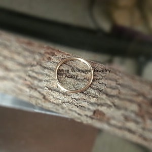 May include: A close-up of a gold wire wrapped ring on a piece of wood. The text "Wire Wrapped Jewelry &copy; Azshy" is visible in the image.