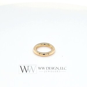 May include: Gold seamless ring with a smooth, polished finish. The ring is open and has a hinged closure.