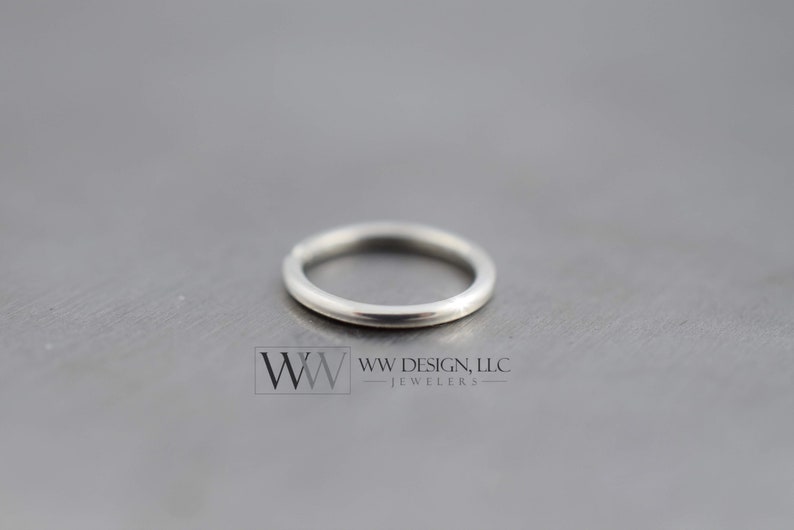 May include: A silver ring with a smooth, polished finish. The ring is a simple, classic design.