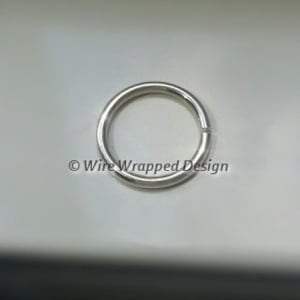 May include: A silver jump ring, a metal ring used for connecting jewelry or other crafts.