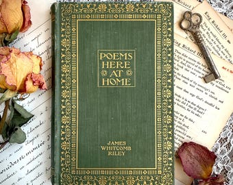 May include: A green hardback book titled Poems Here at Home by James Whitcomb Riley with gold embossed lettering and a decorative border. The book is surrounded by dried roses, handwritten script paper, and a vintage metal skeleton key.