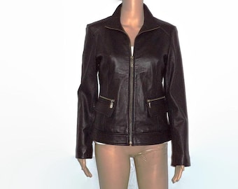 May include: A dark brown leather jacket with a zip-up front and two front pockets. The jacket has a collared neckline and long sleeves. The jacket is displayed on a mannequin against a white background.