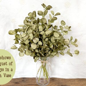 This shows a bouquet of faux eucalyptus in a glass jar. The arrangement contains 6 sprays in a 7 inch vase.