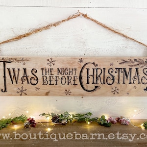 A horizontal wood sign. Twas the night before Christmas and reindeer are wood burned decoratively. The sign hangs with a piece of rope.