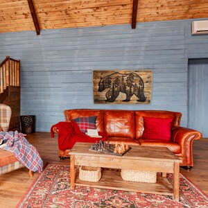 This image shows a handmade piece of rustic wall decor. It features a large bear with a scenic forest inside it. All the artwork is wood-burned by hand onto a pallet of reclaimed wood.