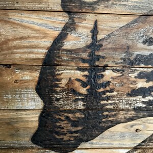 A handmade wood statement piece with a bear and a forest scene.