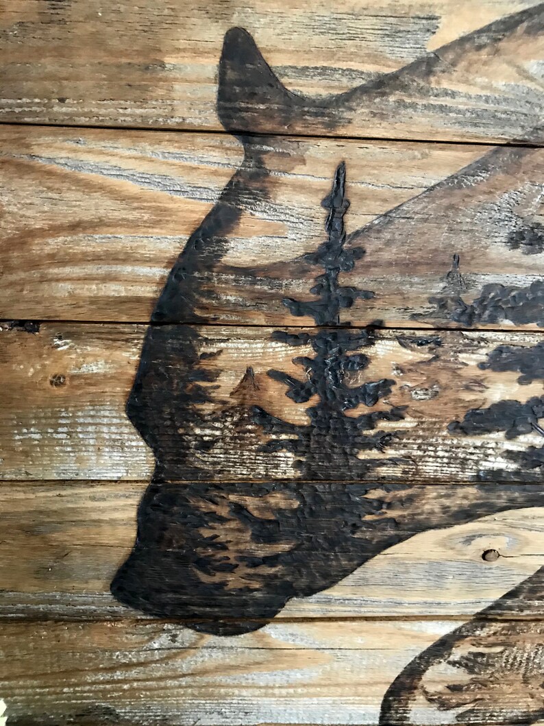 A handmade wood statement piece with a bear and a forest scene.