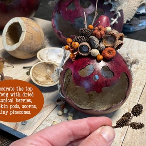 This is a handmade pumpkin decoration. It is a real dried gourd, with a carved ghostly facial expression. I create a fall berry arrangement on the top. I use real dried pods and pinecones.