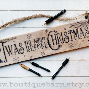 A horizontal wood sign. Twas the night before Christmas and reindeer are wood burned decoratively. The sign hangs with a piece of rope.
