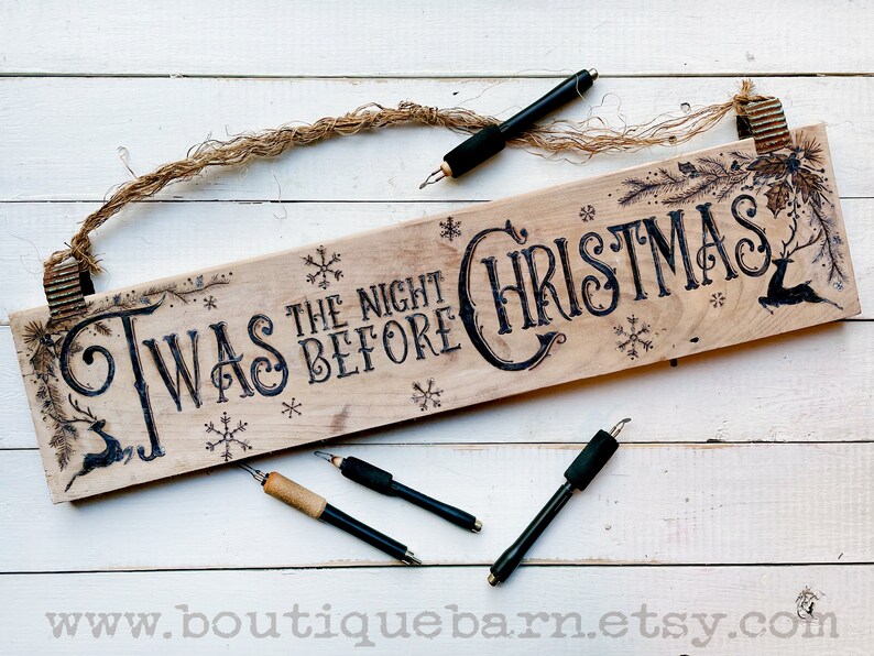 A horizontal wood sign. Twas the night before Christmas and reindeer are wood burned decoratively. The sign hangs with a piece of rope.