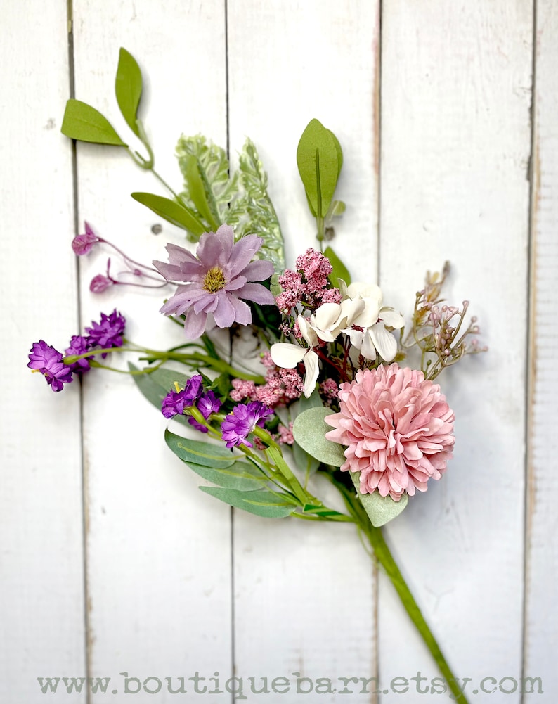 This image shows one faux flower spray. The bundle features a pink mum, a purple daisy, a white hydrangea, and greenery.