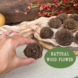 This shows me holding the wood flower blossom in a chocolate brown color. A wood bird house sits in the background