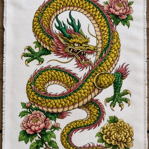 May include: A rectangular white linen towel with a fringed edge featuring a detailed illustration of a long, winding yellow and green dragon with red accents, surrounded by pink and yellow peony flowers with green leaves on a white background.