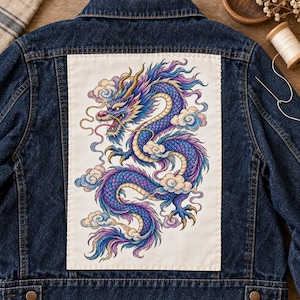 Puede incluir: Una chaqueta de mezclilla azul oscuro con un gran parche de tela rectangular blanco cosido en la parte posterior. El parche muestra una ilustración detallada y colorida de un dragón largo y sinuoso en tonos azul, morado y dorado, rodeado de nubes.