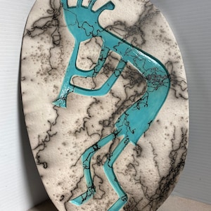 Azulejo colgante de pared Kokopelli en color terracota y turquesa, cocido en crin de caballo